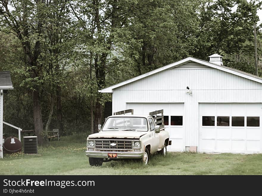 Gray Chevrolet Car Parked Near White Shed