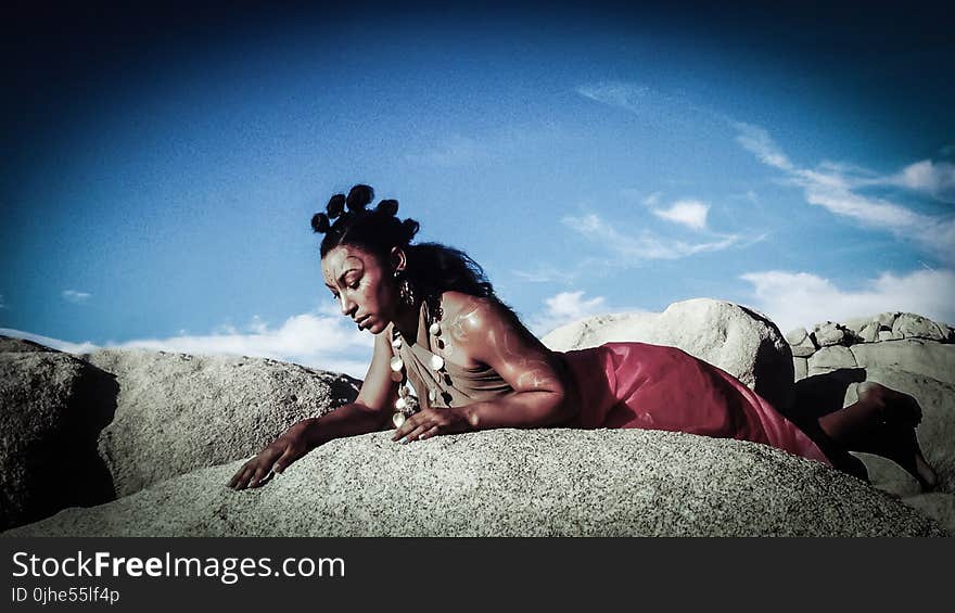 Woman Posing on Top of Stone Under Blue Sky