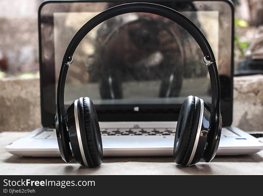 Photo of Black Wireless Headphones in Front of the Laptop