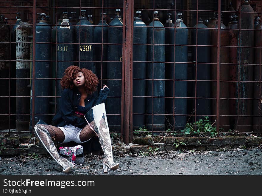 Woman Sitting Beside Tanks