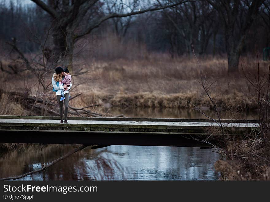 Photo of Mother and Child Standing on the Bridge