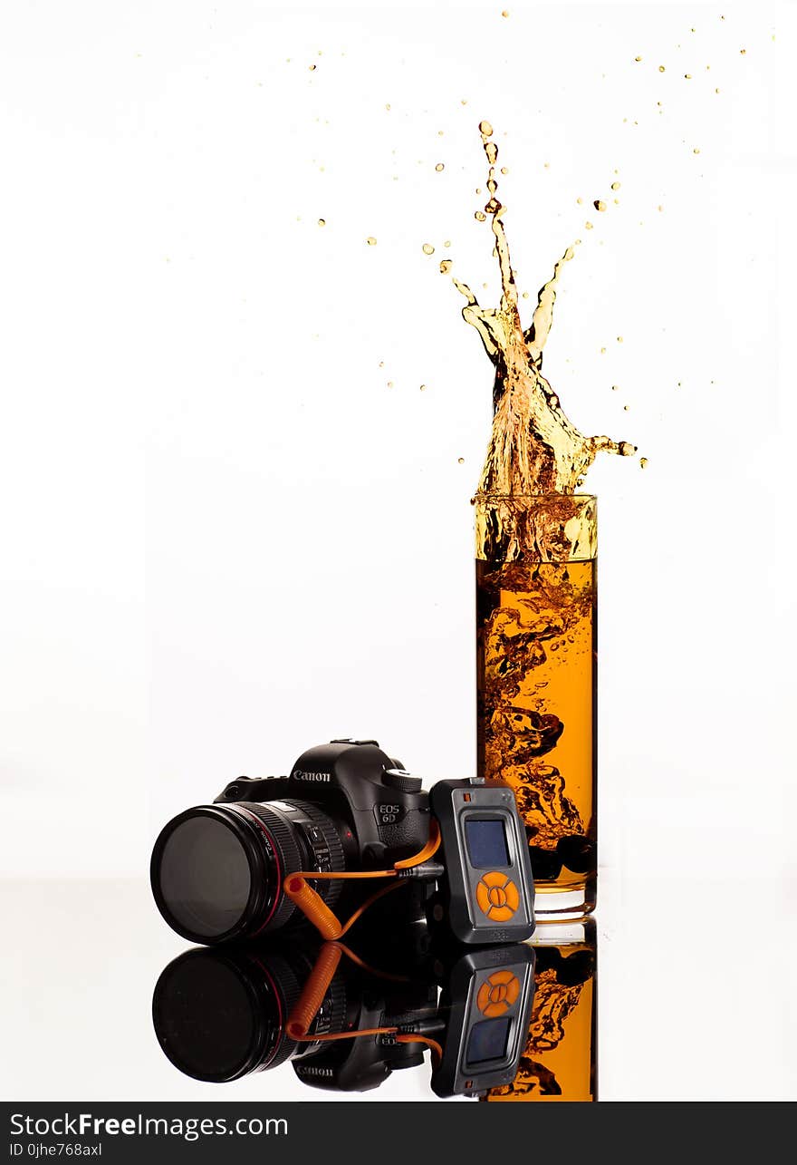 Black Canon Dslr Camera Behind Clear Highball Glass