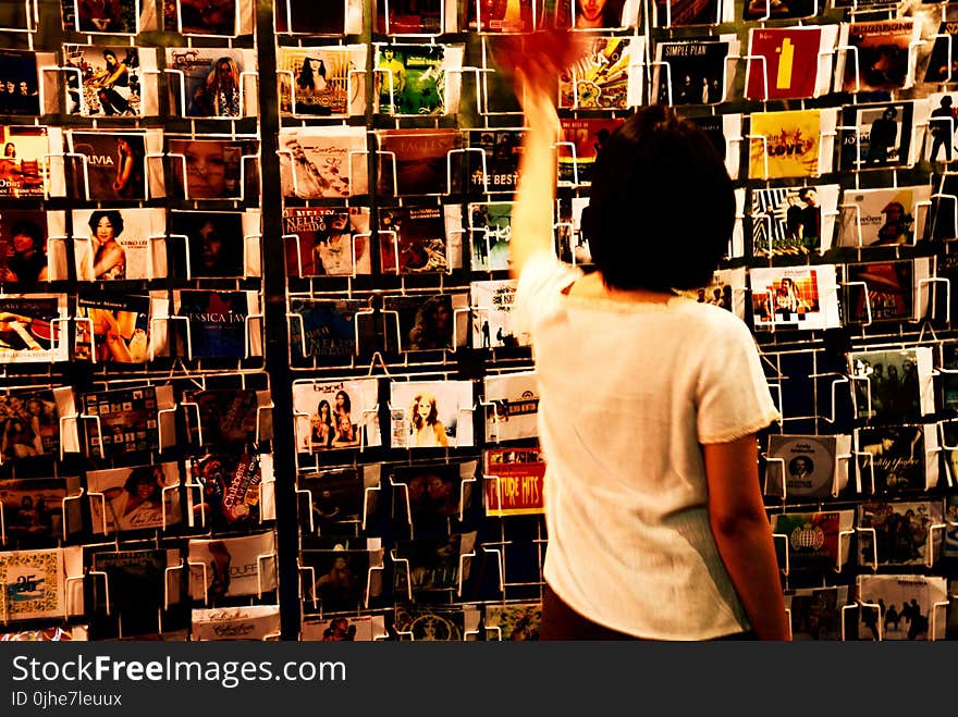 Person Wearing White Shirt Holding Vinyl Albums