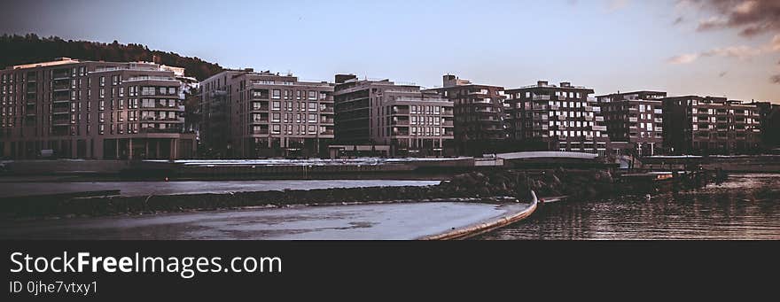 Landscape Photography of Body of Water Beside High Rise Building during Golden Hour