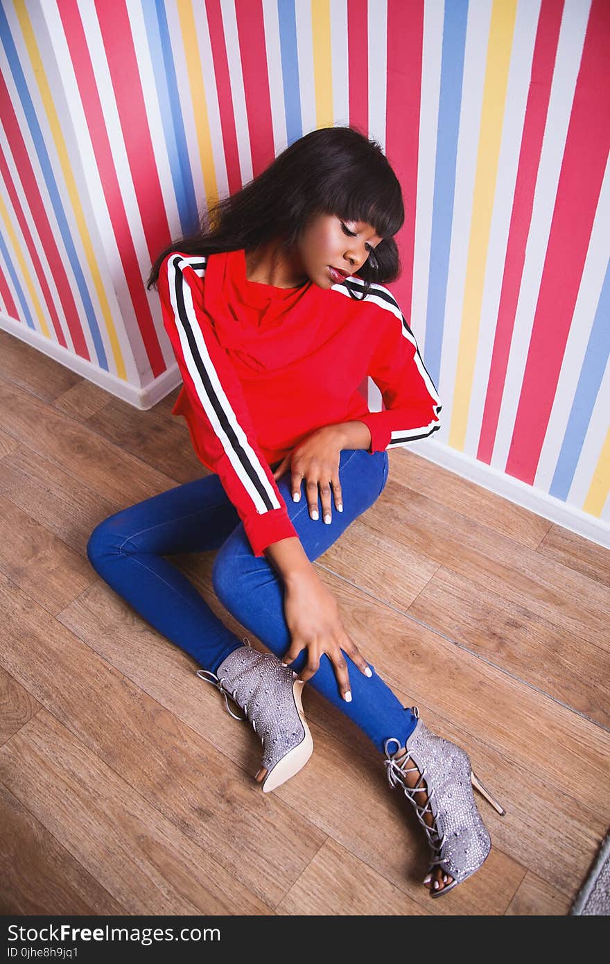 Woman With Red Long-sleeved Shirt Sitting on the Floor Looking Down