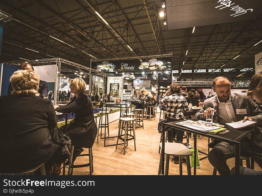 People Inside a Cafe With Tables and Chairs