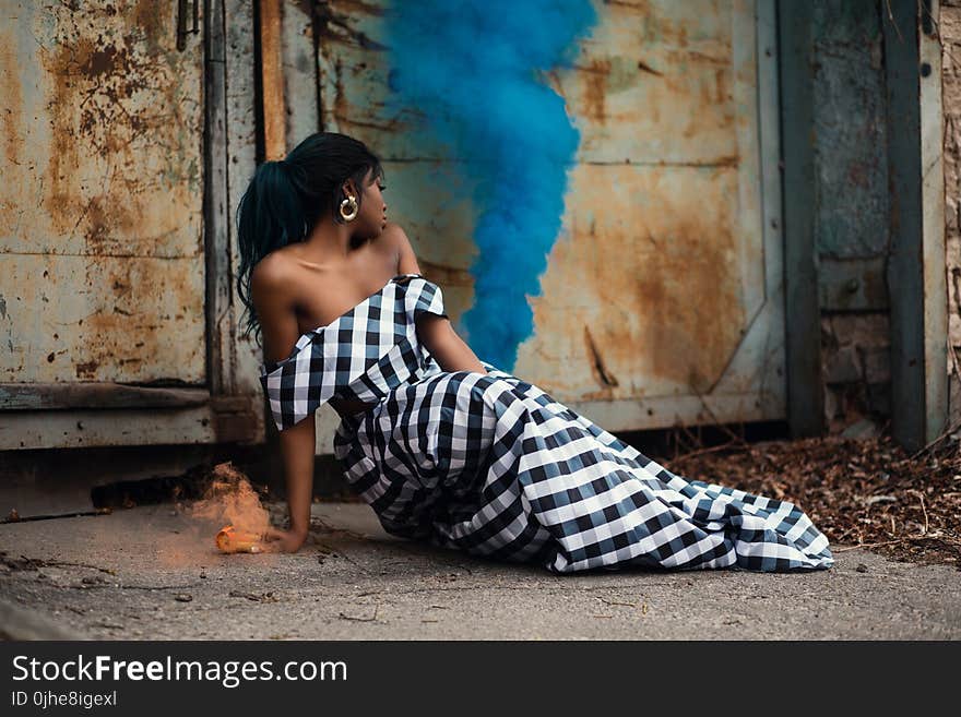 Photo of Woman Wearing White and Black Gingham Dress Sitting on the Floor