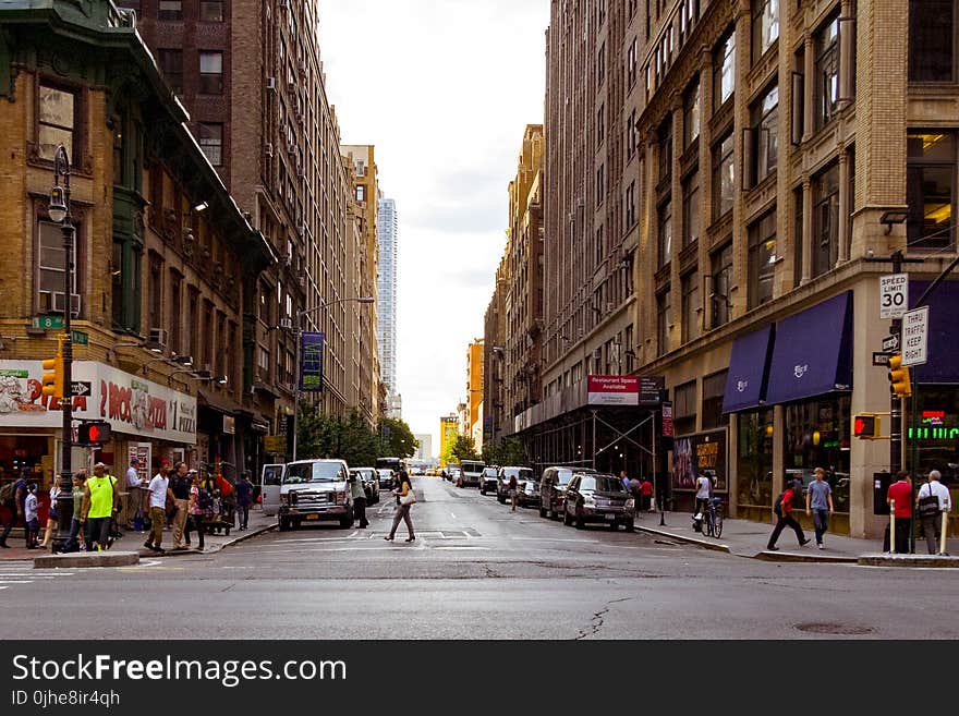 People Walking on Alley Surrounded by High Rise Buildings