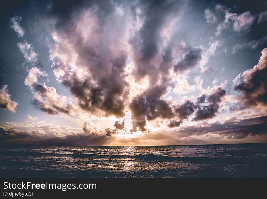 Calm Body of Water With Cloudy Skies