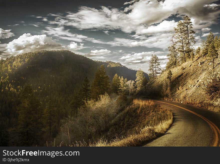 Curved Asphalt Road Between Mountains