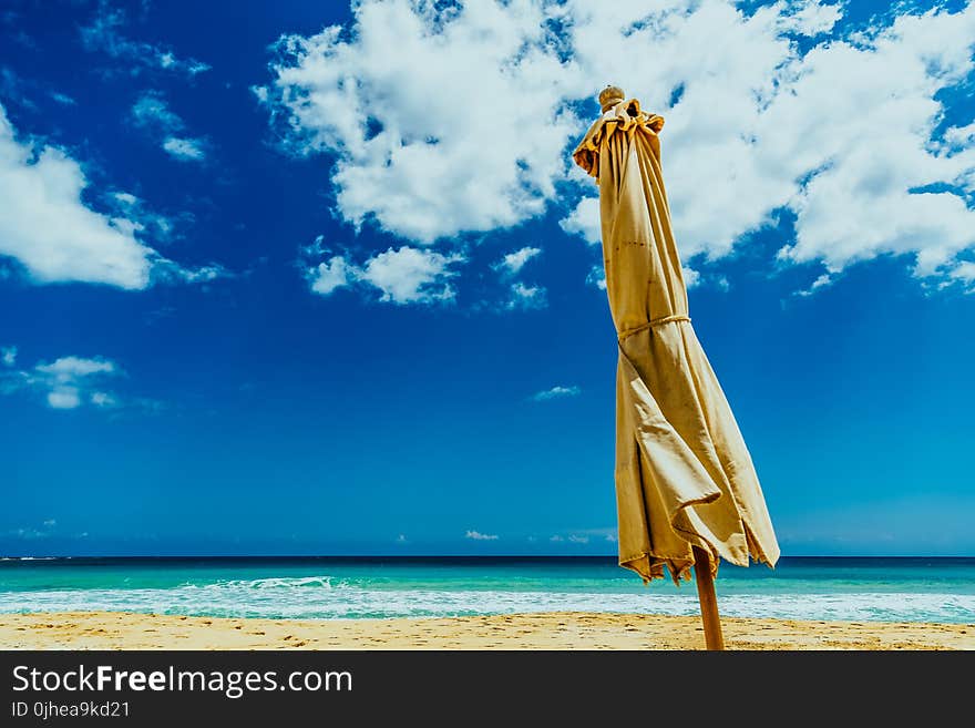 Brown Umbrella on Seashore