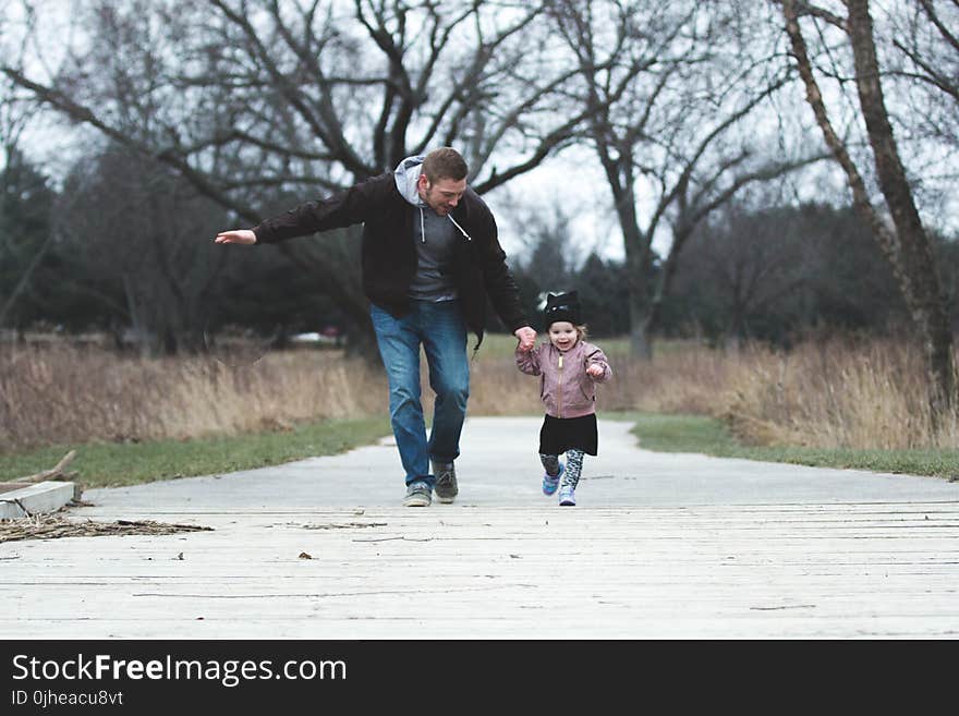 Man and Girl Running on Asphalt Road