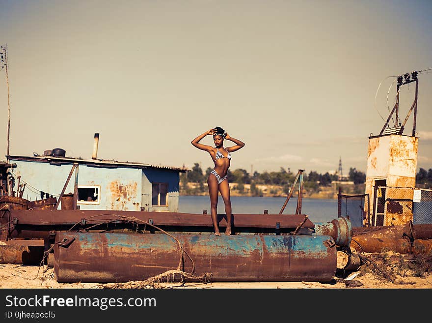 Woman Standing on Brown Steel Container Wearing Two-piece Bikini