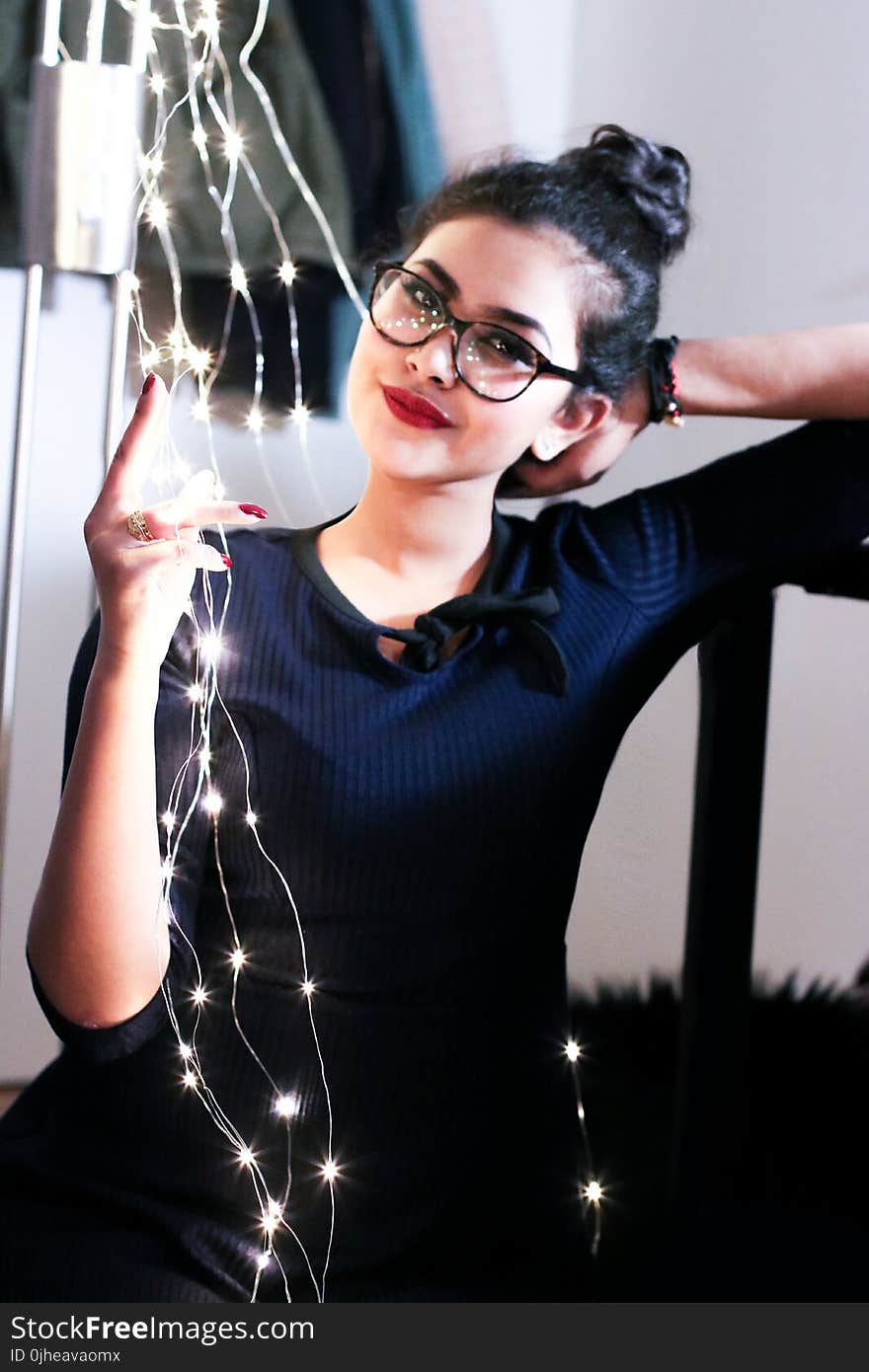 Woman Wearing Black Knit Elbow-sleeved Top Touching Mini String Lights