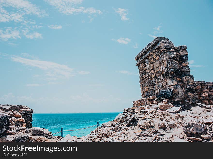 Rocky Terrain Near Sea Under Blue Skies