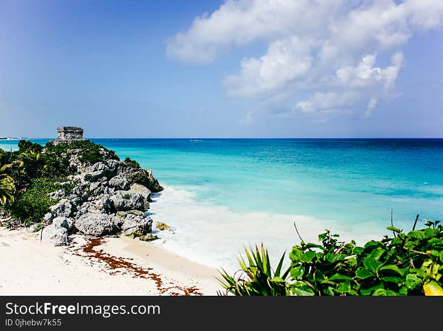 Sea Near Island Under Blue Sky