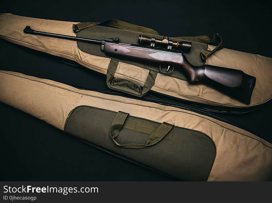 Black Rifle With Scope and Brown Gig Bag