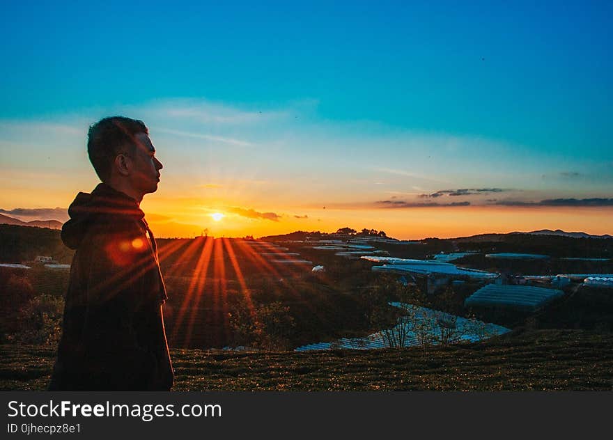 Photo of a Man Wearing Hoodie During Sunset