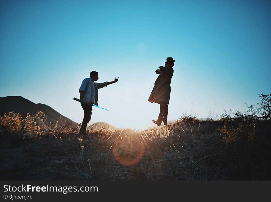 2 Man Standing on Mountain during Day Time