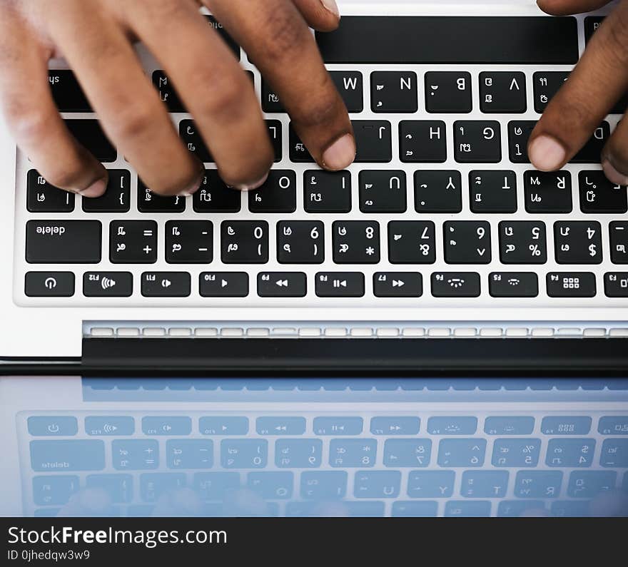 Person Typing on White and Black Laptop Computer