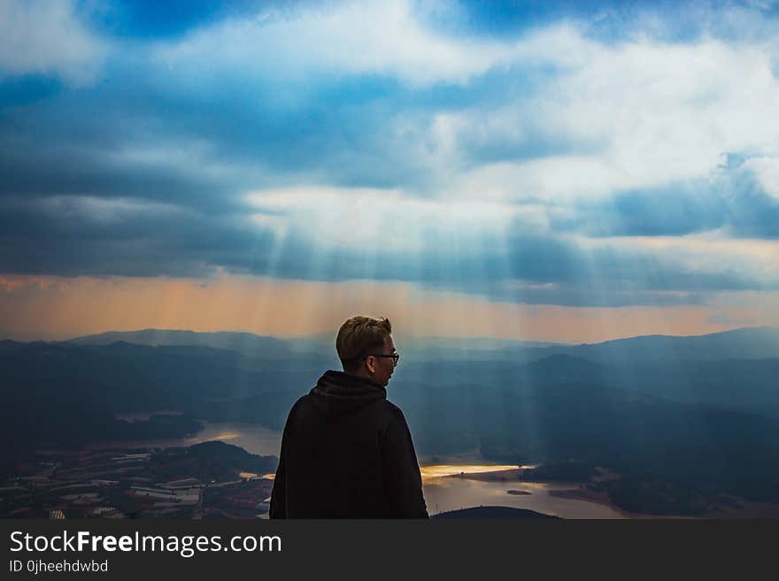 Man Wearing Black Jacket Above The Mountain