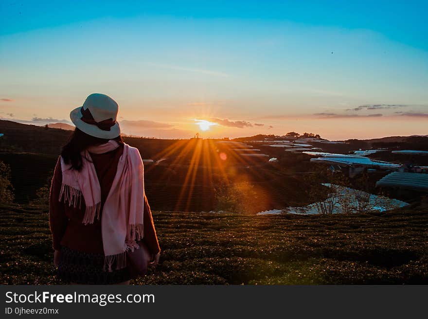 Person Wearing White Fedora Hat and Pink Scarf during Golden Hour