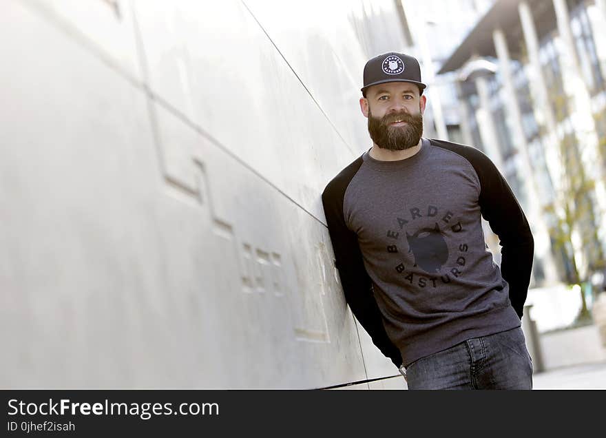 Man Leaning Against the White Concrete Wall