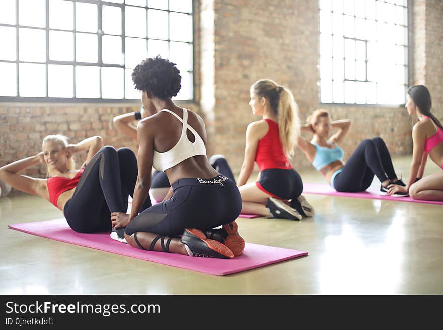 Woman Wearing White and Black Sweat Suit Doing Curl Ups