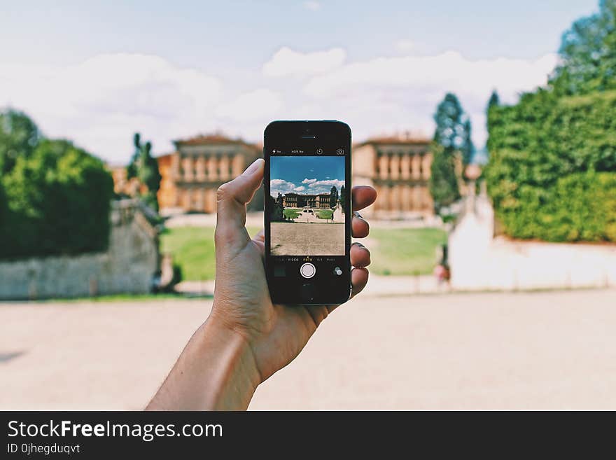 Person Using Space Gray Iphone 5s Taking a Picture of Landmark during Day