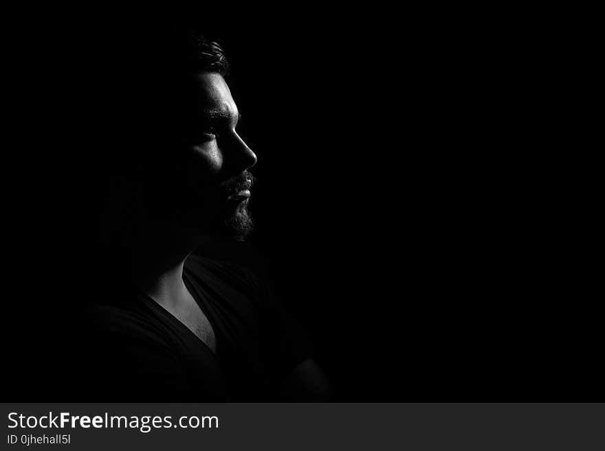 Grayscale Photo of Man in Black V Neck Shirt With Black Background