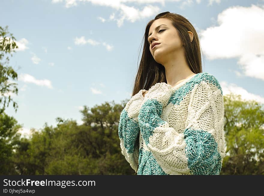 Woman in White and Teal Crochet Dress Under Cloudy Sky