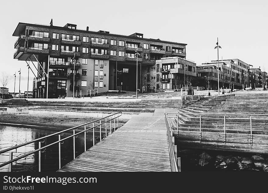 Gray Scale Photo of a Dock Near a Building