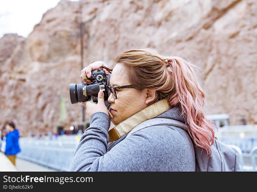 Woman Wearing Gray Jacket Using Black Dslr Camera