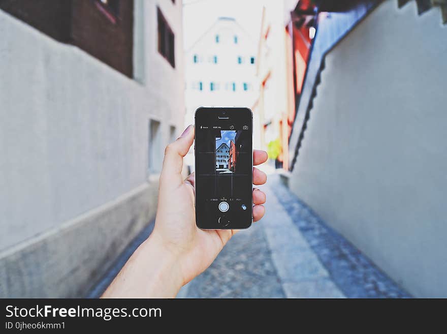 Person Using Space Gray Iphone 5s Taking a Picture of Building during Day