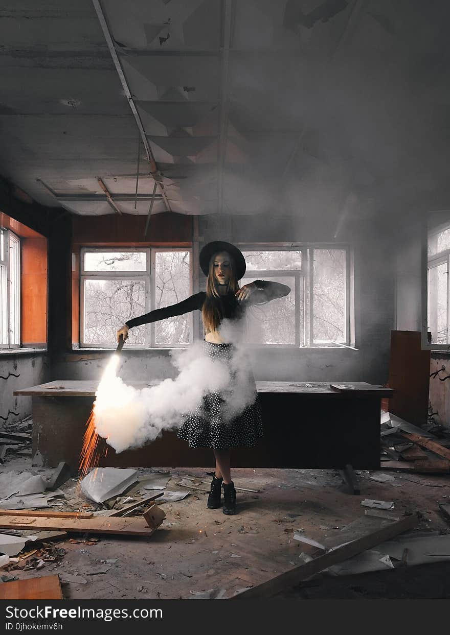 Woman Holding Smoke Flare Standing Front of Table Inside House