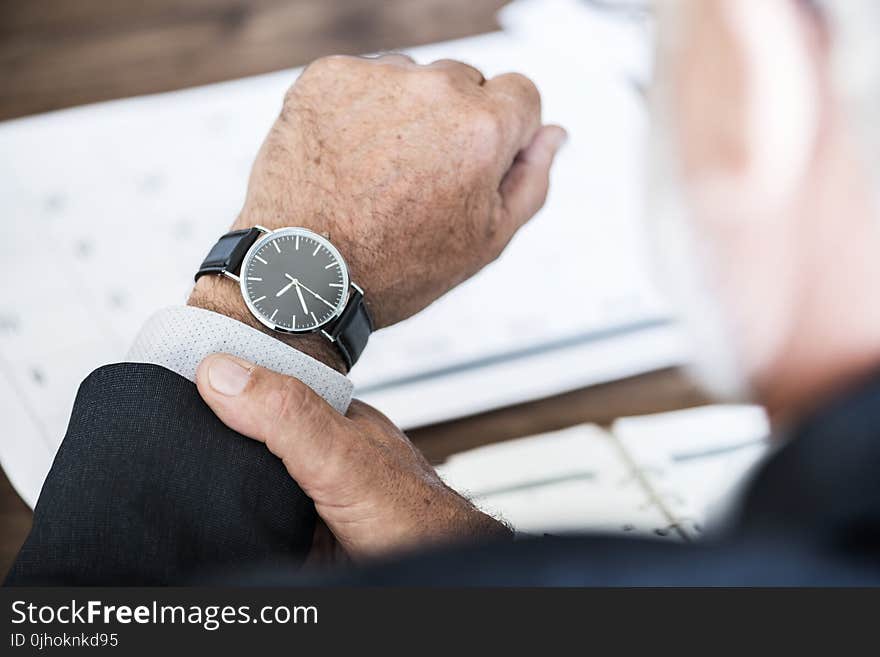 Selective Focus Photo of a Person Wearing Round Watch at 9:36