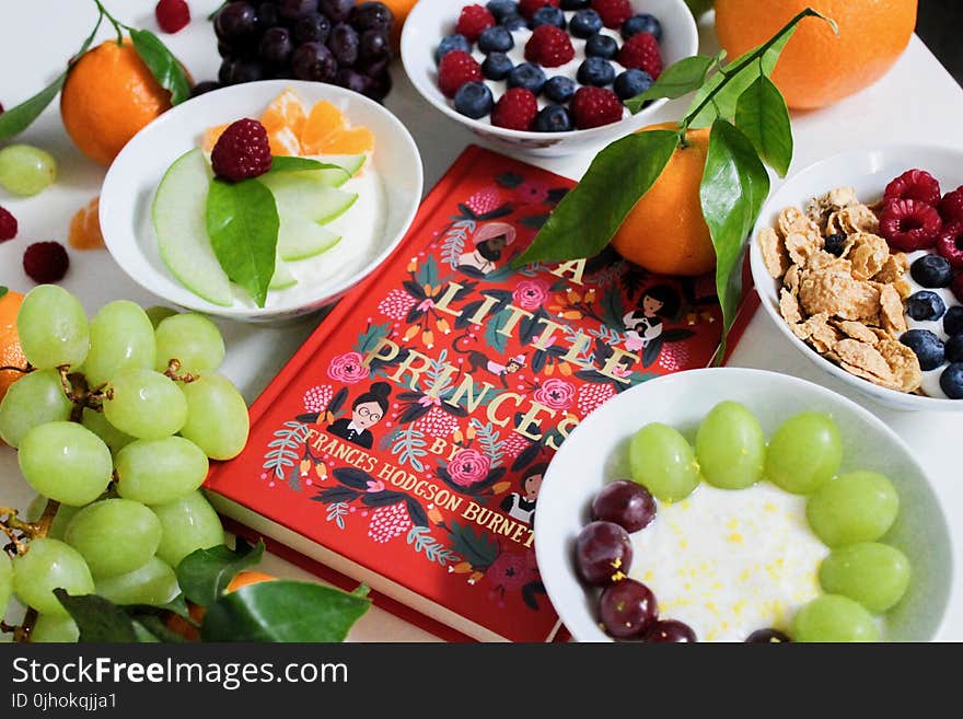 Fruits on Plates Beside Red Book