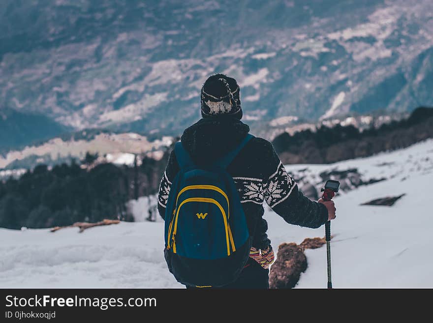 Man in Black and White Jacket and Blue Backpack Doing Snow Ski