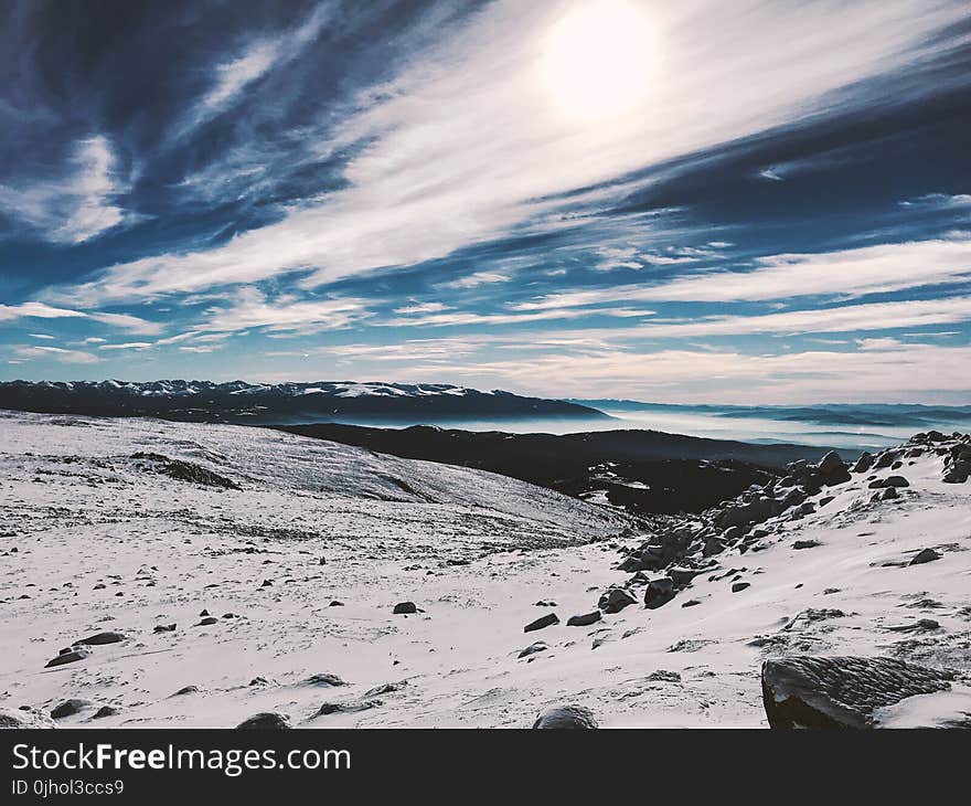 Snow Covered Hill Under Cloudy Blue Sky