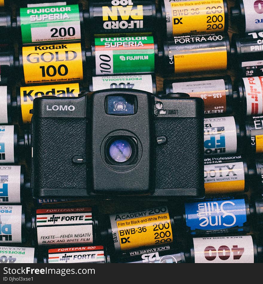 Black Lomo Camera on Top of Photo Films Lot