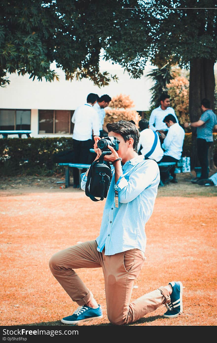 Man Holding a Black Dslr Camera