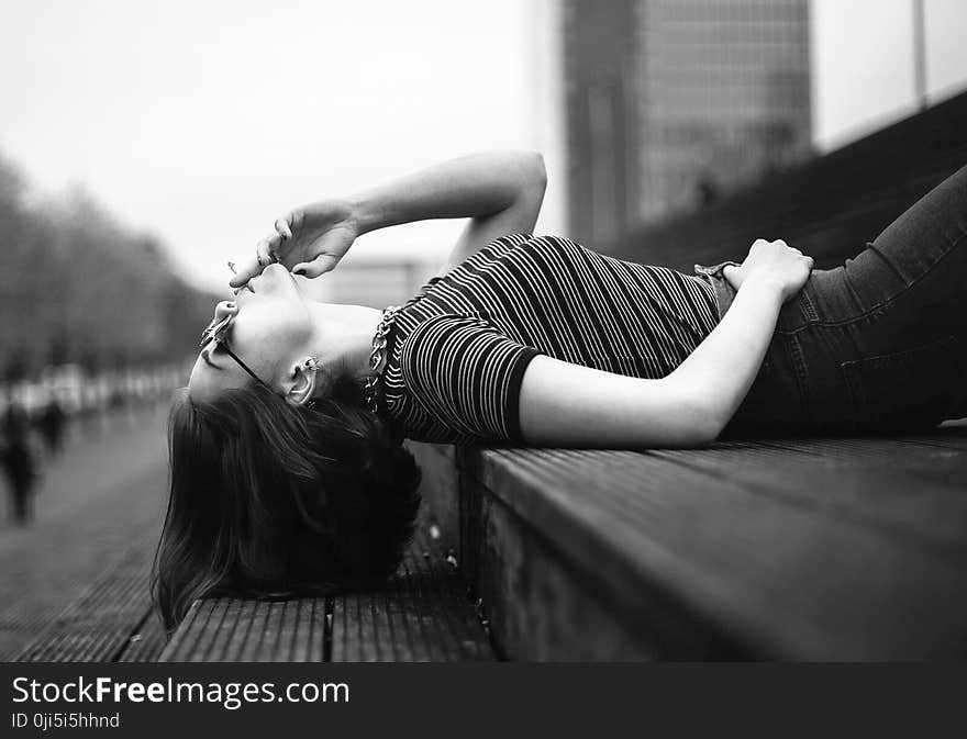 Woman Laying on Stairway Grayscale Photo