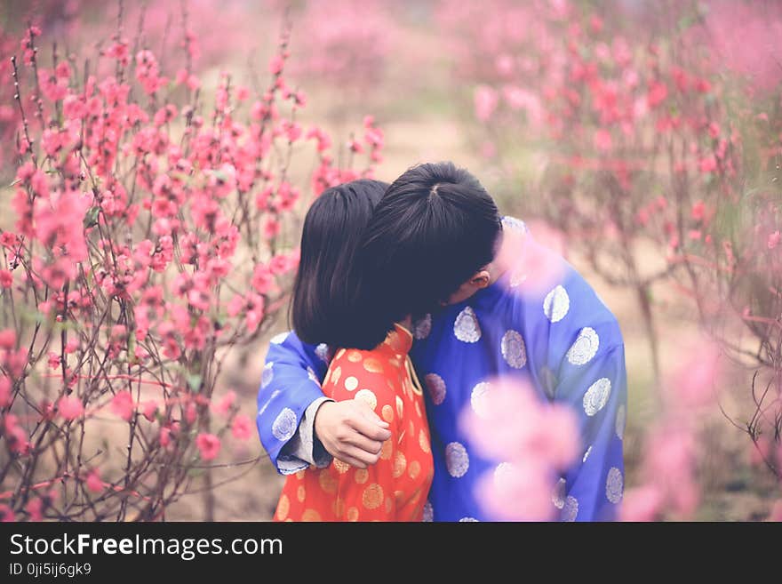 Man Hugging Girl in Orange Clothes