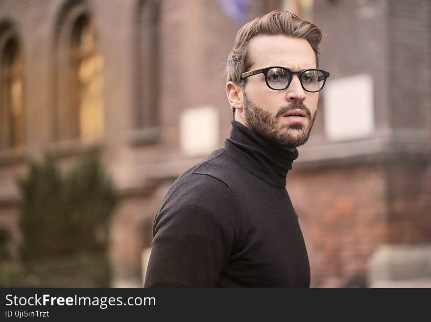 Man Standing Near Building White Black Turtleneck Shirt