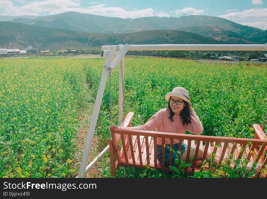 Woman Sitting on Brown Swing