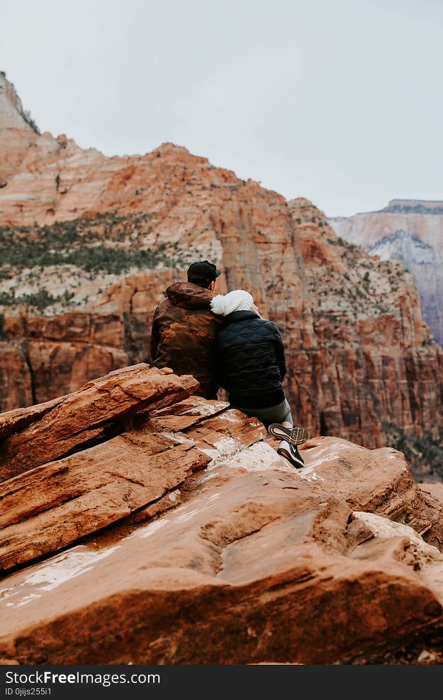 Couple Sitting on Rock Cliff