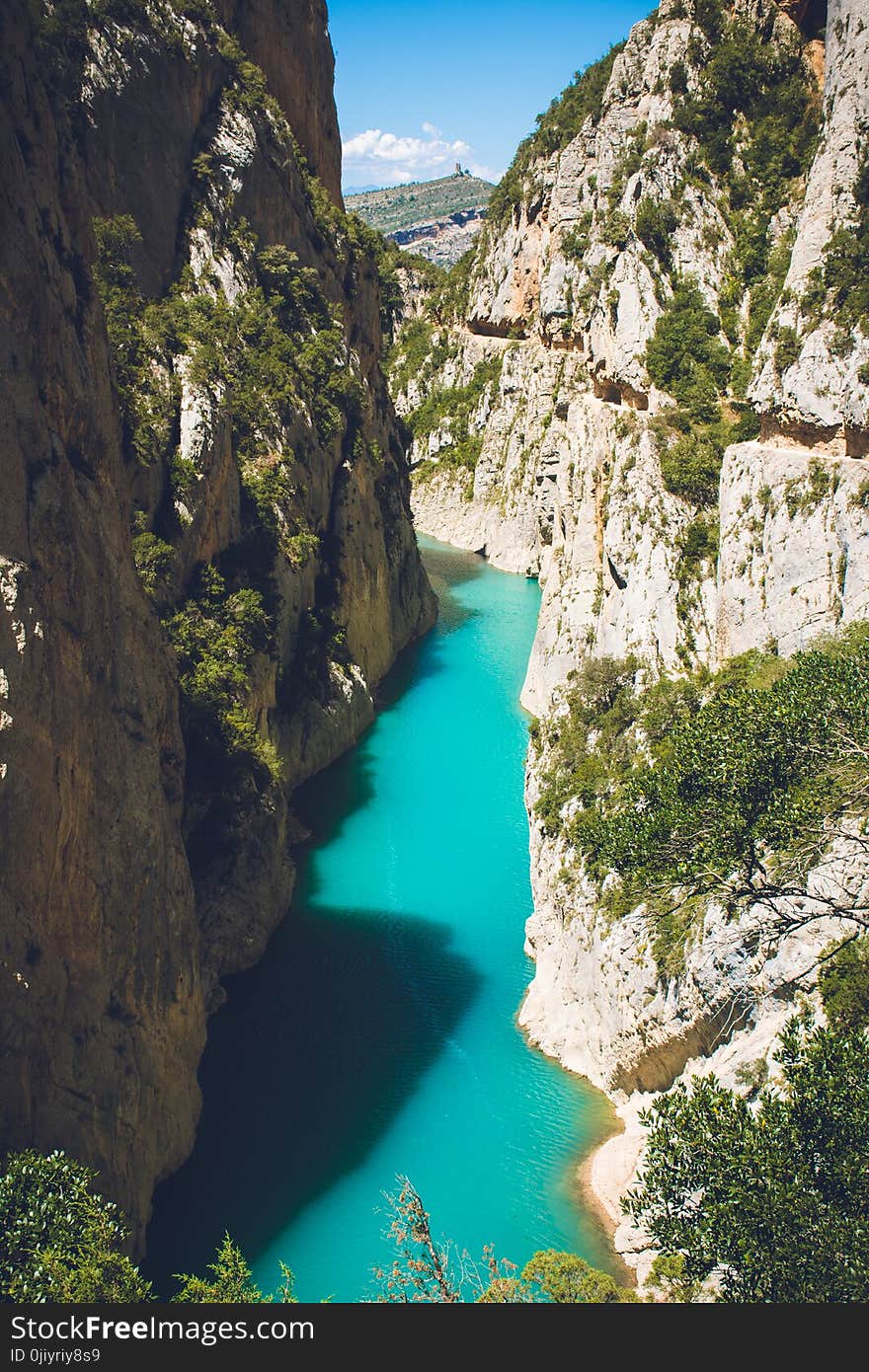 Body of Water in Between of Rock Formation Under Blue Sky at Daytime