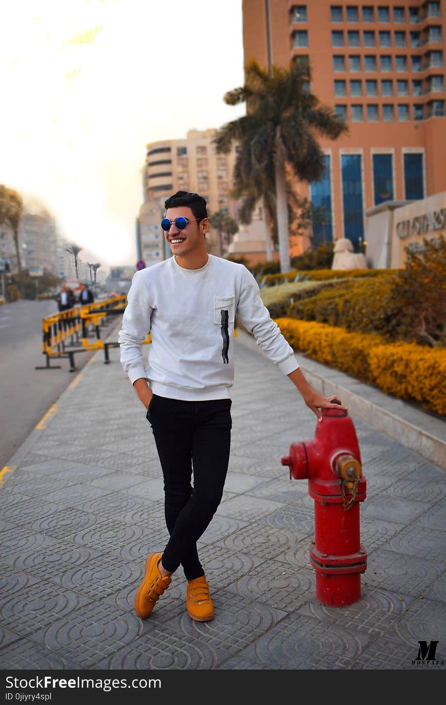 Man in White Long-sleeved Shirt Holding Red Fire Hydrant