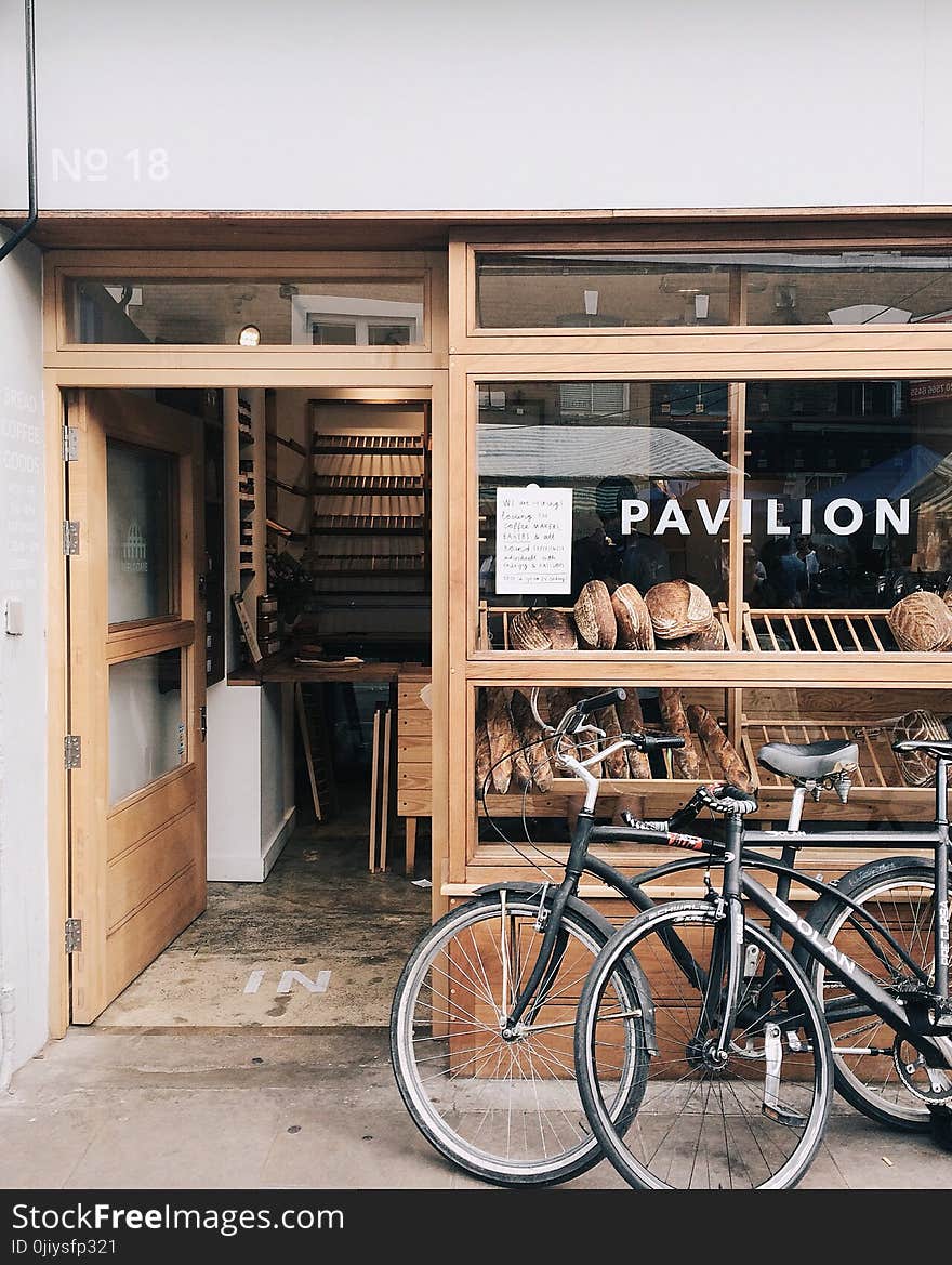 Two Black Bicycles Beside Gray Frame Glass Window