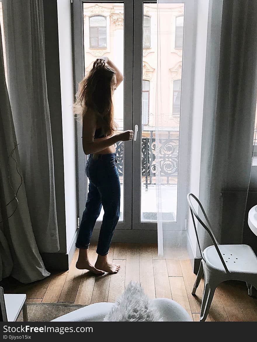 Photo of Woman in Blue Pants Holding Her Hair